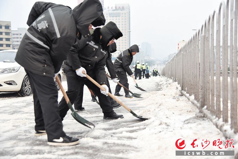 1月28日早上，芙蓉区城管执法人员在东二环团结立交桥上铲冰除雪。市城管执法局供图