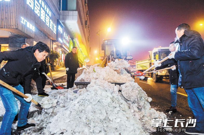 昨晚9时，车站北路，芙蓉区湘湖街道城管工作人员正在对路边的积雪进行统一清理。 长沙晚报记者 邹麟 摄
