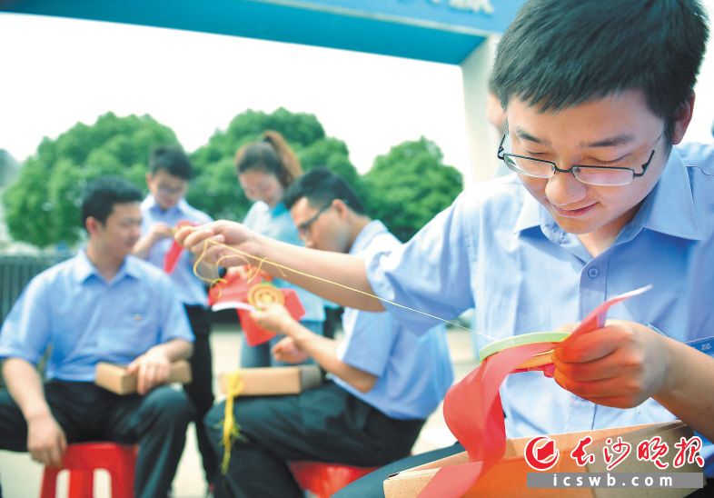 在湘绣师的悉心指导下，建筑工人一针一线绣团旗。长沙晚报记者 小刘军 摄