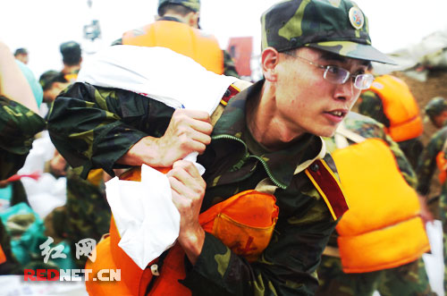 武警战士背沙包固堤坝