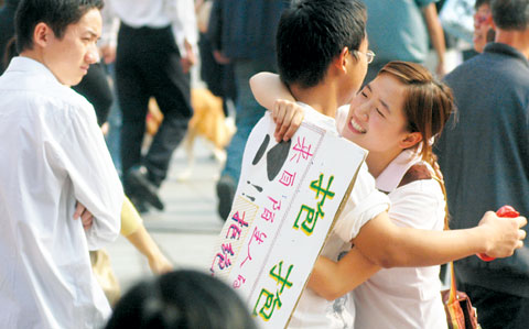 10月29日,长沙市黄兴路步行街,女孩举着“抱抱”的纸牌向路人索要拥抱。当日,一个名为“抱抱团”的民间组织在长沙发起公益行为艺术活动记者伍霞摄