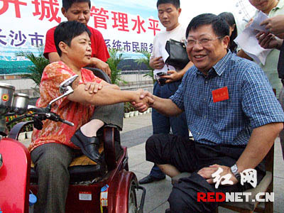 长沙市城管局局长吴念公（右）与身残志坚的市民蒋素芬在面对面交流