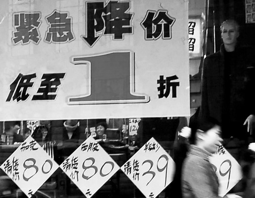 昨日,东塘某品牌店贴出商品降价的海报。元旦购物高峰到来,商家纷纷开始打折促销吸引顾客。图/记者刘艳