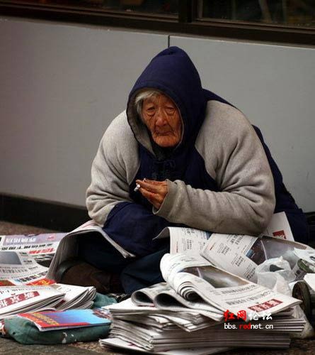 80岁年迈老妪寒风中卖报