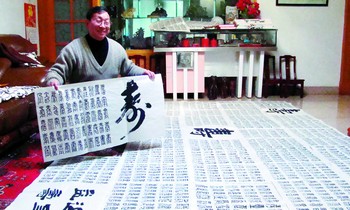 朱建南先生正高兴地向大家展示他花费6年时间创作的“百福万寿”图。均为陈暄/摄