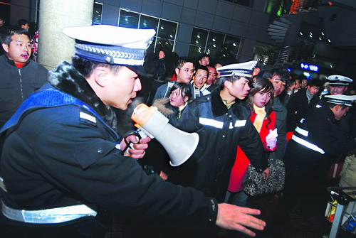 昨晚,机场公安局警察在组织滞留旅客上大巴,前往市内宾馆住宿。昨日,受冰冻天气影响,黄花机场两度关闭,多趟航班被迫取消,6000余名旅客滞留。机场方面妥善做好滞留旅客安置工作。图/记者刘艳