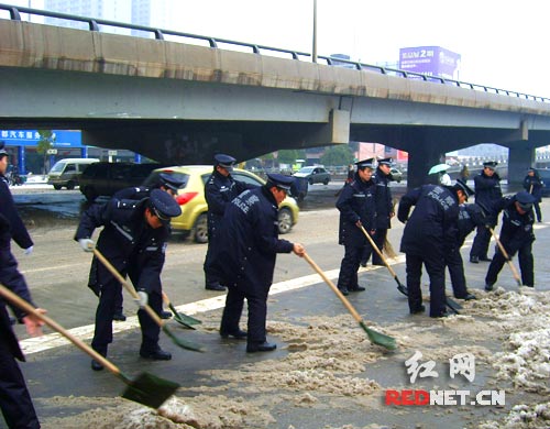 特警们出动除冰扫雪,保障城区交通畅通。