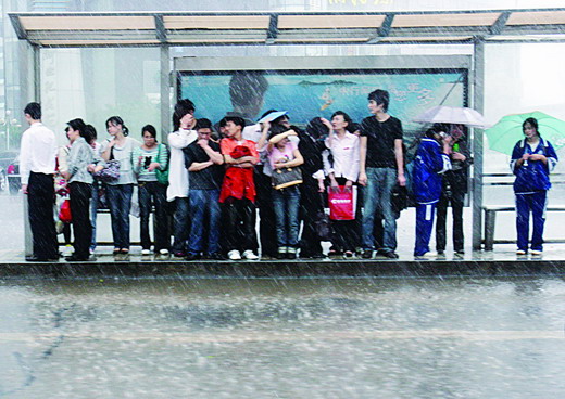 市民躲进公交车站避雨。图/记者殷建军