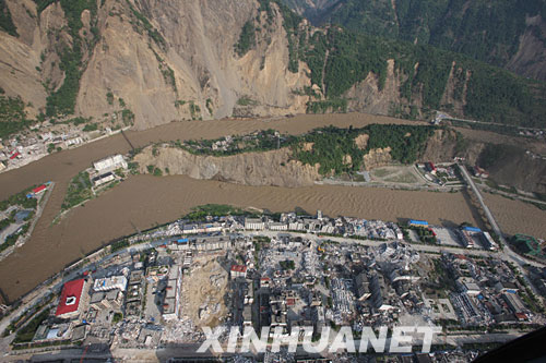 这是6月10日上午,记者搭乘济南军区某陆航团直升机从空中拍摄的四川唐家山堰塞湖泄流洪水流经北川县城的情况。 截至6月10日9时30分,唐家山堰塞湖泄流渠流量达到1760立方米每秒,泄流量进一步加大,堰塞湖下游的北川流量达2240立方米每秒。