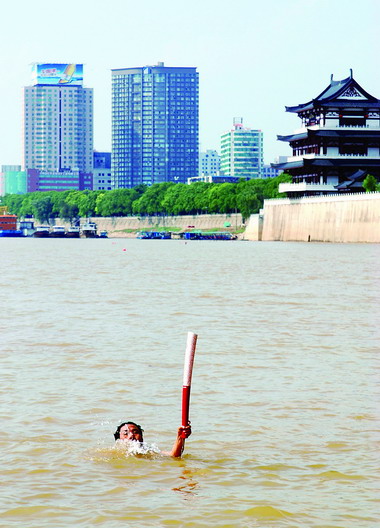 63岁老人举着奥运火炬横渡湘江