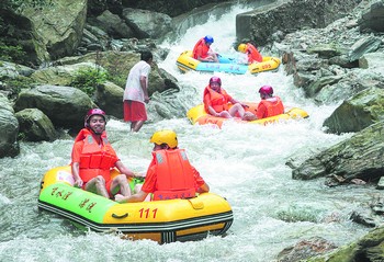 几名游客在湖南·娄底·龙山飞水漂流首漂式上冲浪.郭国权 摄