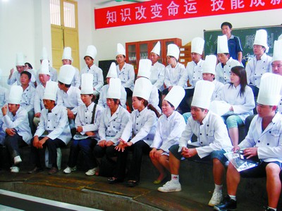 带上高耸的厨师帽,穿着白色工作服,46名返乡农民工专心致志听中国烹饪