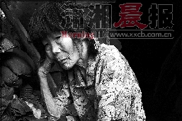   老人在“家”门口发呆，眼神中充满着期待。