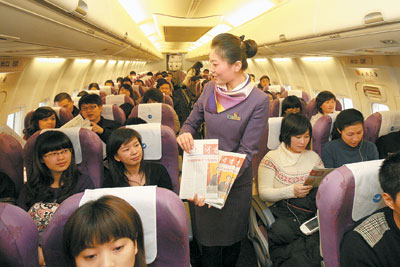 空姐在飞机上为乘客分发当天的《湖南日报》