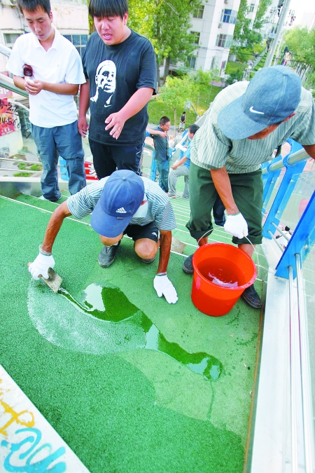 施工人员正在给地垫刷固化胶水