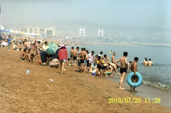 组图:周末大连海滨浴场游人戏水纳凉