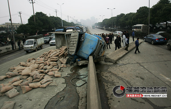 大卡车撞飞10米护栏侧翻路中 15吨水泥洒满一