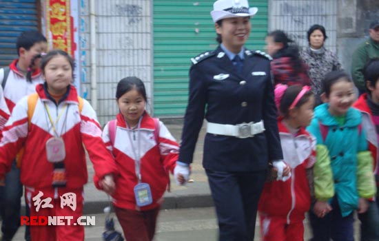 (隆回县交警队女民警带领学生过马路)