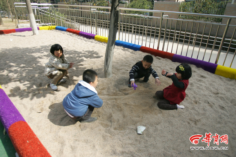 小区里的孩子在沙坑里玩耍