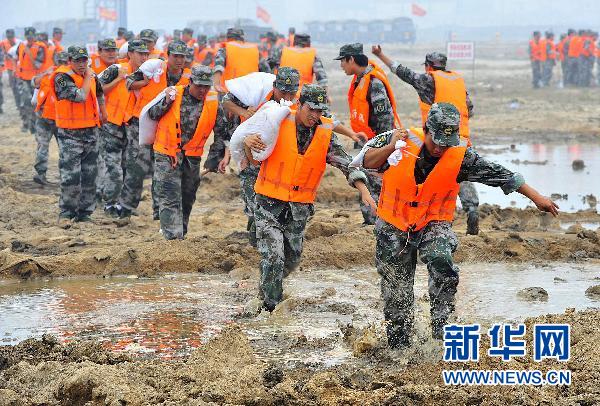 7月6日,在天津应急能力建设检验性考核比武现场,应急分队执行防汛抗洪任务。当日,一场应急能力考核大比武在天津滨海新区举行,47支民兵、预备役专业应急分队6000多名队员全副武装,以主汛期海河滨海新区塘沽段出现大规模险情为背景,按照快速收拢、快速到位、快速控局、快速转换四个阶段进行抗震救灾、森林灭火、反恐维稳、防汛抢险等全方面演练。新华社发(王晓明 摄)