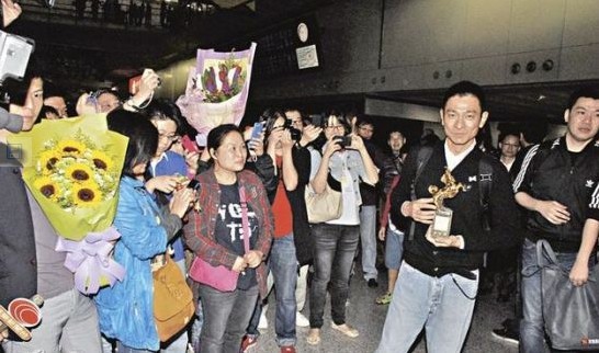 刘德华再次捧着金马奖回香港,粉丝机场接机送花祝贺