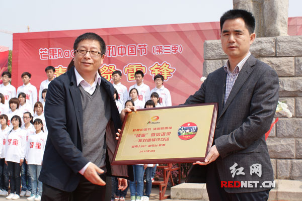 湖南广播电视台副总编辑盛伯骥（左）向望城雷锋纪念馆馆长陈亮伟（右）赠送《怀念雷锋微信语录》。