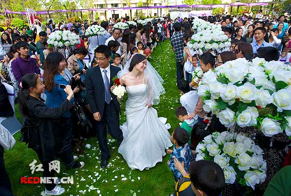 一对对走进婚礼现场的新人们受到全场人们的热切关注。