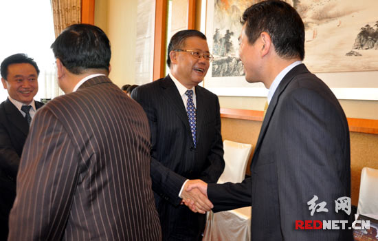 胡彪（左三）、陈叔红（左一）与参加“2012世界华商领袖峰会”的嘉宾握手。