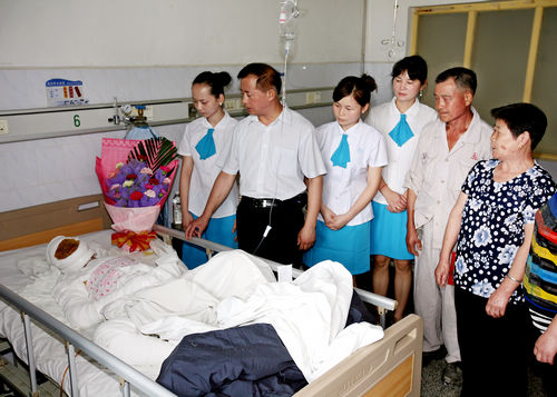 图为湖南十三村食品公司志愿者到医院看望慰问烧伤的柴斌芳老人.