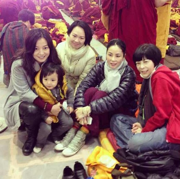 (赵薇抱着女儿小四月与王菲和友人合照.)