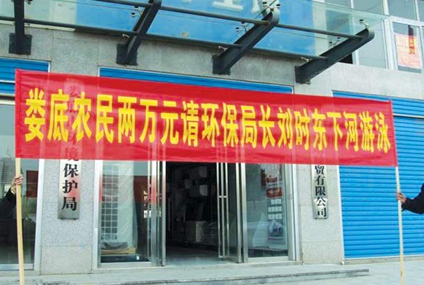(4月8日,村民拉横幅请娄底市环保局局长刘时东下河游泳。资料图片) 红网娄底4月13日讯(潇湘晨报滚动新闻记者 朱远祥)饮用水水源变质,娄底三元村民喝桶装水6年,维权招数使尽,最后拉横幅到环保局及区政府门口,请领导下河游泳。 这其中的无奈,或许只有当地村民才能体会。 村民行为或许有点过激,但如果不是挂横幅,情况会怎样?民生无小事,相对于领导的委屈,村民的委屈实则最大。本报记者朱远祥娄底报道 两位老人站在娄底市环保局门口两侧,拉起一条横幅:娄底农民两万元请环保局长刘时东
