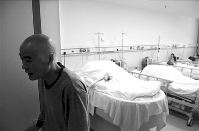 父亲李明为接受手术剃成了光头，离开病房准备去手术室。　京华时报实习记者摄/视频