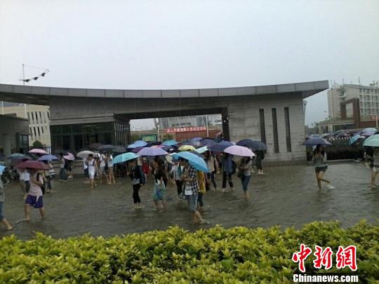 10日下午，位于福州市西郊的大学城福建医科大学校门口出现积水，大学生淌水上课。　汤珺琳　摄