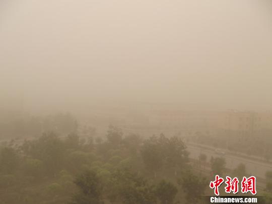 沙尘暴来袭,地处塔克拉玛干沙漠前沿的新疆生产建设兵团第一师塔里木垦区十四团团部小城镇被湮没在沙尘中。 李江帆 摄