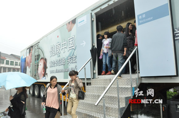 5月18日，在长沙县乡间路边，湖南省内300余名基层医生参观一辆独特的大卡车。