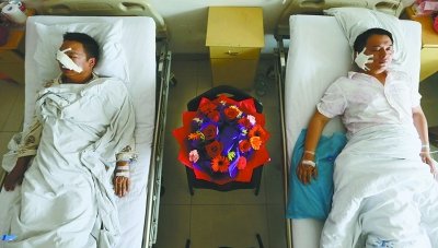 身受重伤的两位民警在医院接受治疗，战友们送上康乃馨祝福他们早日康复。