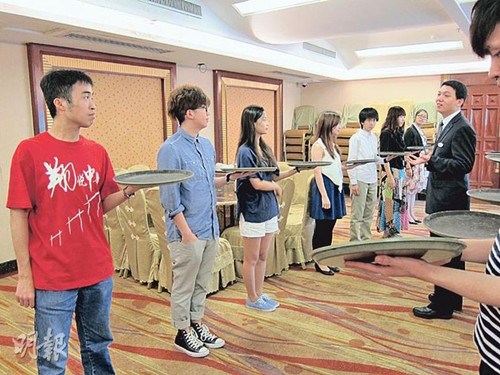 李启禧(左一)去年在内地酒店实习学捧餐,他指酒店业虽不是他在大学所修的科目,但仍感兴趣,将来亦有意到内地闯一闯。(受访者提供,香港《明报》发)