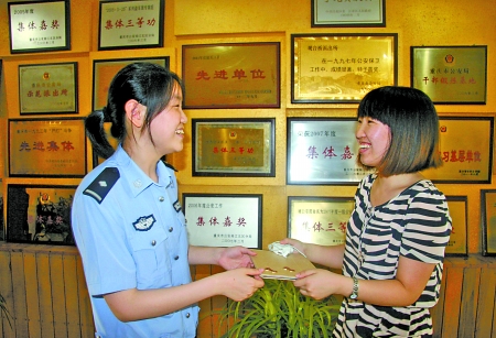 昨日，观音桥派出所，民警将iPad交还给赵英。 通讯员 张明权 记者 吴珊 摄