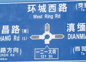 李老师提供的三张照片中，路牌上的“一二一大街”标注了三种英文注解