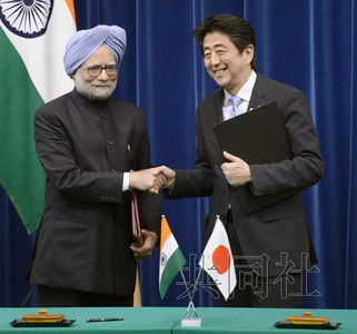 5月29日,日本首相安倍晋三在官邸与印度总理辛格举行会谈。图为两人签署联合声明后握手。
