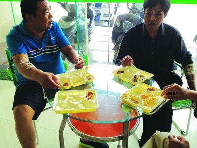 几名带着胶管的患者，边吃盒饭边向记者讲述经过。记者喻莉 摄