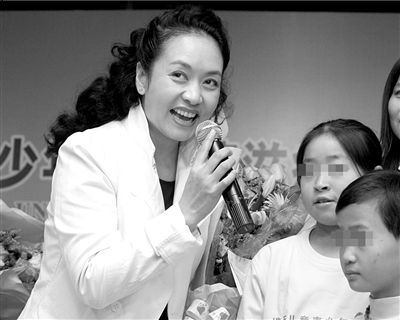 2006年9月10日，卫生部预防艾滋病宣传员彭丽媛和受艾滋病影响的孩子在一起。图/CFP