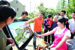 李全兴（图中穿橙色T恤男子）向村民讲解山泉新村小区规划图 资料图片