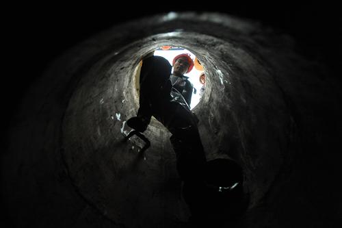 在广西南宁市银海大道,一名工人进入下水道准备进行清淤作业(2012年11月12日摄)。新华社记者 周华 摄