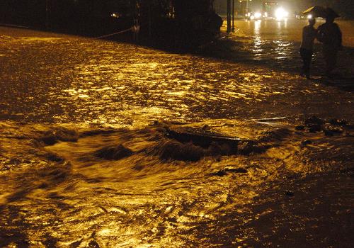在广西南宁市竹溪立交桥下,雨水从一处下水道井口喷涌而出(2010年5月29日摄)。新华社记者 周华 摄