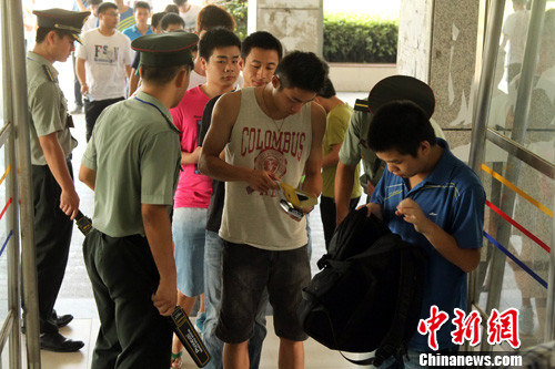 6月15日，江西南昌华东交通大学四、六级考点，考生正通过安检进入考场。中新社发 姜涛 摄