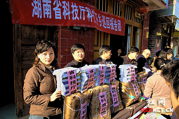 湖南省科技厅政策法规处调研员王红（左一）与同事一起向群众赠送科普类读物。