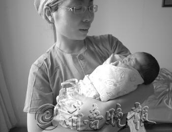 护士怀中的女婴多多。　本报记者　张榕博　摄