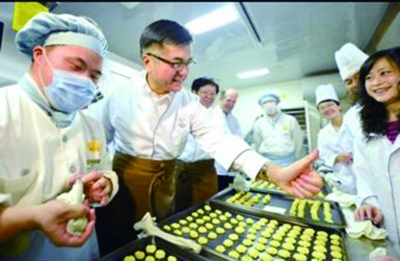 骆家辉在爱德面包坊里。万程鹏 摄
