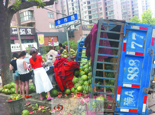 侧翻的西瓜车旁围了很多爱心市民